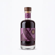 A bottle of Elder Black Forest elderberry liqueur with a purple label and a wooden stopper, shown on a clean white background.