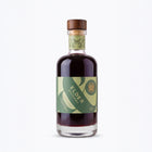 A 200ml bottle of Elder Orchard liqueur against a clean white background. The bottle is made of clear glass, filled with a very dark purple-black liquid, and features a green and light green label with a wooden stopper.