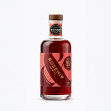 A 200ml bottle of Wild & Wonder Rosehip Spritz liqueur with a red and pink label, gold lettering and wooden cap, with a 2-star Great Taste 2026 award tag on the neck.