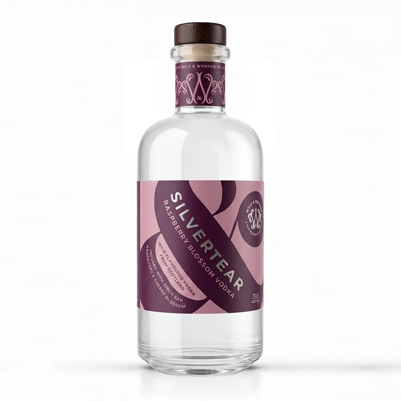 A bottle of Silvertear Raspberry Blossom Vodka on a plain white background. The clear glass bottle features a dark brown wooden cap and a pink and purple label with white text.