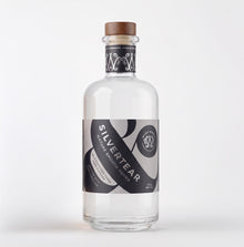 A clear glass bottle of Silver Tear Nature smooth birch sap vodka with a brown wooden cap, featuring a black and grey label with white text, set against a plain white background.